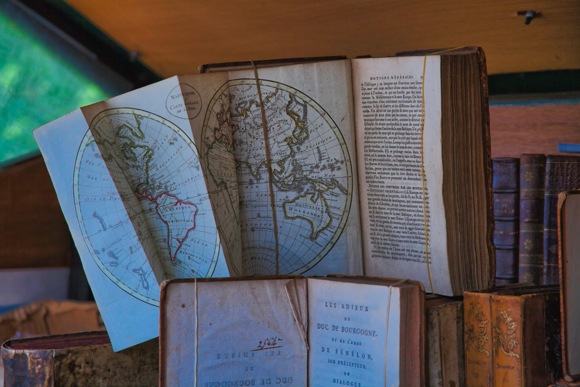 a stack of old books with maps on them